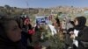 Afghan women's rights activist group hold flowers as they gather at the grave of Farkhunda.