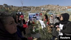 Afghan women's rights activist group hold flowers as they gather at the grave of Farkhunda.