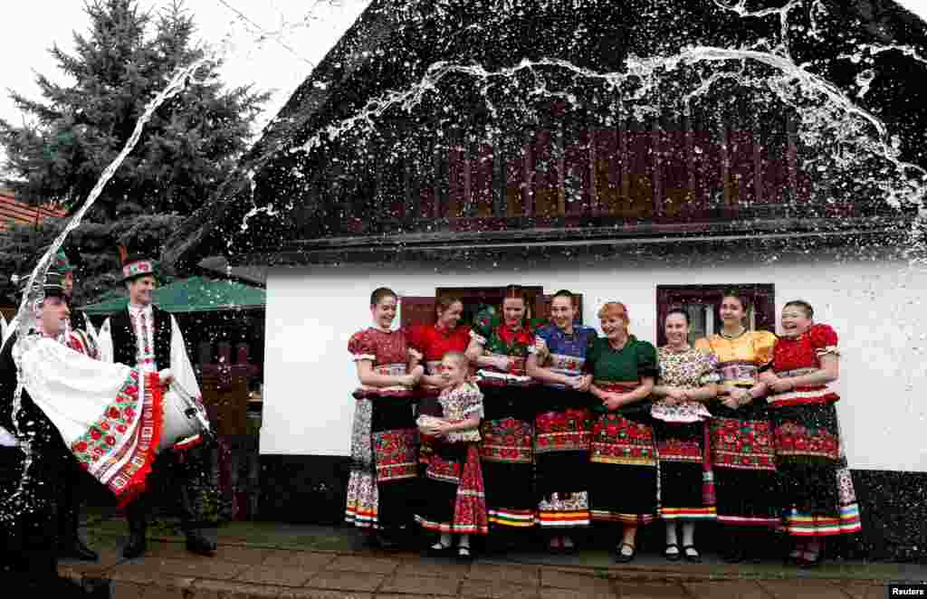 Burrat hedhin ujë mbi gratë si pjesë e festimeve tradicionale të Pashkëve në Mezokovesd, Hungari.&nbsp;