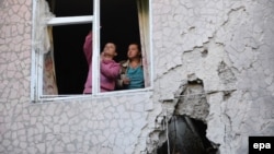 Locals fix a window shattered during shelling in Slovyansk.