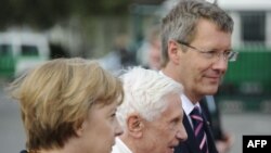 German Chancellor Angela Merkel (left) and German President Christian Wulff (far right) welcome Pope Benedict upon his arrival in Berlin.