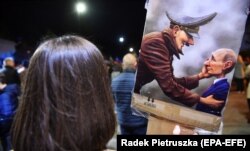Плакат с изображением Адольфа Гитлера и Владимира Путина во время акции у российского посольства в Польше против вооруженной агрессии России по отношению к Украине. Варшава, 10 октября 2022 года