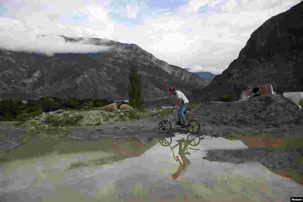 A man rides his bicycle in the mountain village of Gimry.