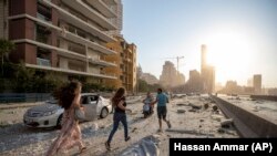 Люди бегут по улице после взрыва в Бейруте. 4 августа 2020 года. 