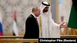 Президент России Владимир Путин и фактический правитель ОАЭ, наследный принц Абу-Даби Мохаммад бин Заид Аль-Нахайян во время военного приема в президентском дворце в Абу-Даби, 15 октября 2019 года
