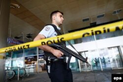 Вооруженный полицейский в аэропорту Стамбула после теракта. 29 июня 2016 года.