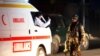 An Afghan soldier stands guard as ambulance arrives at the site of an attack in Kabul late on December 24.