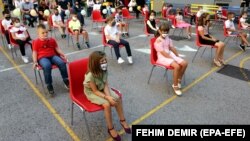 Учні молодших класів із дотриманням дистанції (але не всі в масках) у перший шкільний день у школі в Сараєві, Боснія і Герцеговина, 1 вересня 2020 року