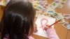ВИЧ-инфицированная девочка рисует красную ленту, символ борьбы со СПИДом, в шымкентском Центре матери и ребёнка. 30 ноября 2020 года. О массовом заражении детей ВИЧ в городе стало известно в 2006 году