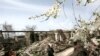 A woman walks past buildings ruined in the August 2008 fighting in South Ossetia's Tskhinvali.