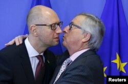 Jean-Claude Juncker primindu-l pe premierul ucrainean Arseni Iațeniuk la Bruxelles, 7 dec., 2015.