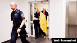 Швед полициячилари Нодира Аминова шахсиятини ҳимоя қилиш мақсадида¸ уни юзига ниқоб тутилган ҳолда маҳкамага олиб келмоқда.