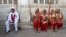 FILE: A groom (L) and four brides sit outside the venue of their weddings as they have arrived late to a mass Muslim marriage ceremony in the western city of Ahmedabad.