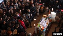 Armenia -- People surround the coffin with the body of six-month-old boy Seryozha Avetisian after he died of his wounds in hospital, following a killing spree last week, during a funeral ceremony in Gyumri January 21, 2015