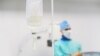 Belarus - Closeup saline intravenous drip. Surgeon is in the operating room on a background. Undated