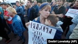 O femeie, aflată la un protest care a avut loc la Sankt Petersburg, pe 5 septembrie, ține o pancartă pe care este scris „Alegerile sunt atunci când poți alege”