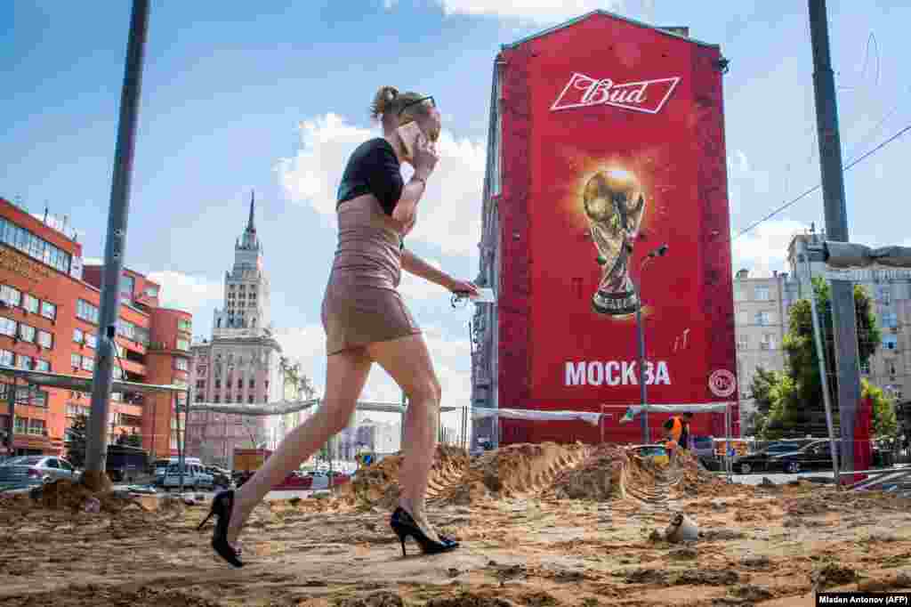 Një grua me taka të larta ecën në një trotuar që është duke u shtruar në qendër të Moskës, pasi qyteti vazhdon me përgatitjet për Kupën Botërore të FIFA-s, të vitit të ardhshëm.