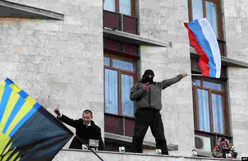 A Pro-Russia supporter waves a Russian flag after storming the regional administration building in Donetsk.