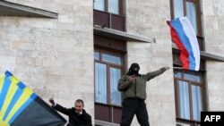 A pro-Russian supporter waves a Russian flag after storming the regional administration building in the eastern Ukrainian city of Donetsk on April 6.