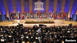 Delegates applaud after the vote at UNESCO headquarters in Paris, where the United Nations' cultural agency decided to give the Palestinians full membership of the body on October 31.