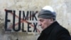 A Kosovar Albanian man walks in front of anti-EU and UN graffiti in the capital, Pristina, in late November.