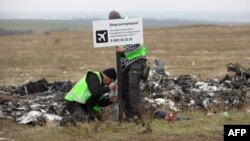 Следователи на месте крушения самолета, выполнявшего рейс MH17 из Амстердама в Куала-Лумпур.