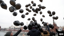 Russian opposition activists and human rights defenders release black balloons in front of the Kremlin to mark the sixth anniversary of the death in prison of lawyer Sergei Magnitsky in Moscow on November 16, 2015.
