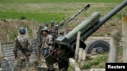 Nagorno-Karabakh -- Ethnic Armenian soldiers stand next to a cannon at artillery positions near the Nagorno-Karabakh's town of Martuni, April 7, 2016