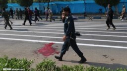 Blood can be seen on the street after gunmen opened fire on a military parade in Ahvaz.