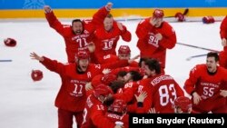 Russian hockey players celebrate after netting the winning goal in overtime to win the gold.