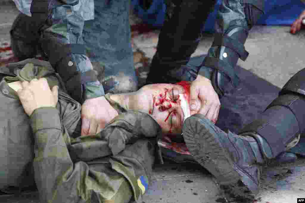 Правоохоронець допомагає товаришу, пораненому під час бійки біля Верховної Ради України. Київ, 31 серпня 2015 року Дивитись ФОТОГАЛЕРЕЮ