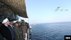 Iranian President Hassan Rowhani (L) attending the navy parade during a military drill in the Oman Sea on December 31.