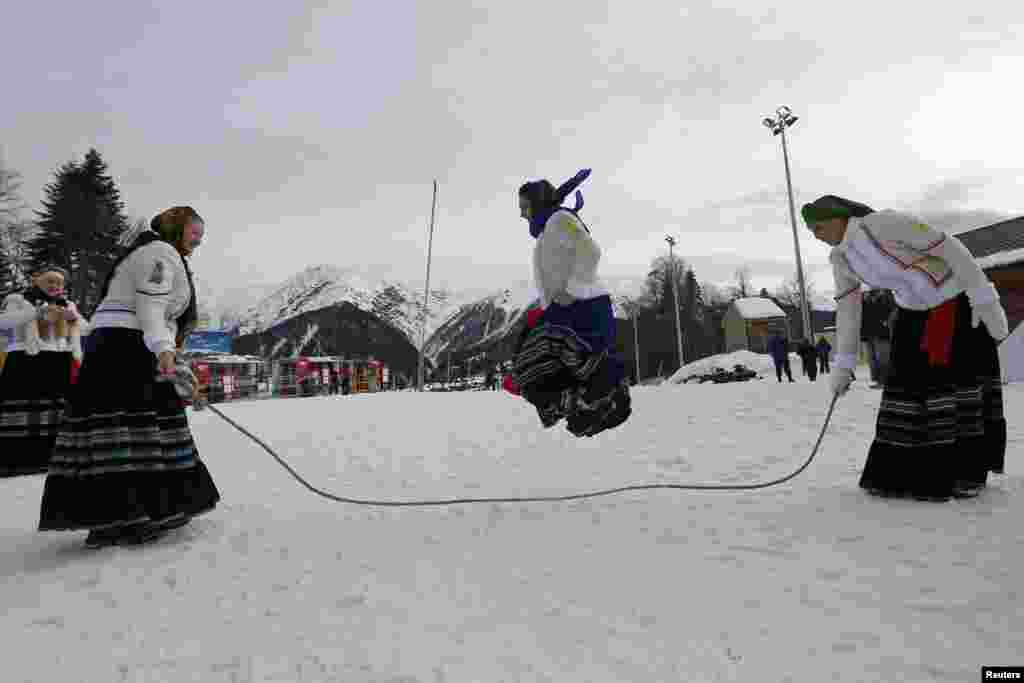 A woman dressed in traditional clothing jumps rope near the Laura cross-country and biathlon center in Rosa Khutor.