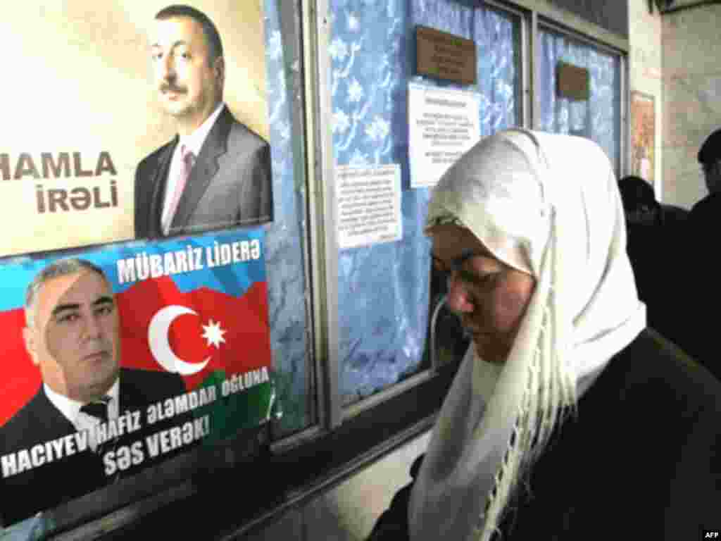 AZERBAIJAN - VOTE AZERBAIJAN, Baku : A woman stands near election posters for current Azeri President Ilham Aliyev (top) and opposition candidate Hafiz Hadjiev (bottom), in Baku on October 14, 2008. The war in Georgia created new dilemmas for its oil-rich neighbour Azerbaijan, which has walked a tightrope between Moscow and Washington while dealing with a simmering ethnic conflict of its own. Aliyev, almost certain to be re-elected for a second term on October 15, has so far managed to maintain good relations with Georgia, Russia and the United States. AFP PHOTO / VANO SHLAMOV 