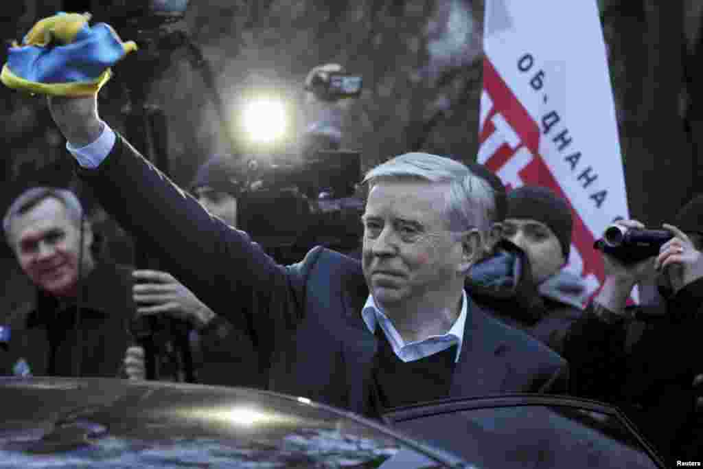 European Union envoy Pat Cox (center) waves to supporters of jailed former Prime Minister Yulia Tymoshenko outside the hospital where she is being held in Kharkiv on November 22. Tymoshenko has called on people to go out onto the streets to protest against the government&#39;s decision not to sign a trade deal with the European Union, her lawyer said. (Reuters/Dmitry Neymyrok)