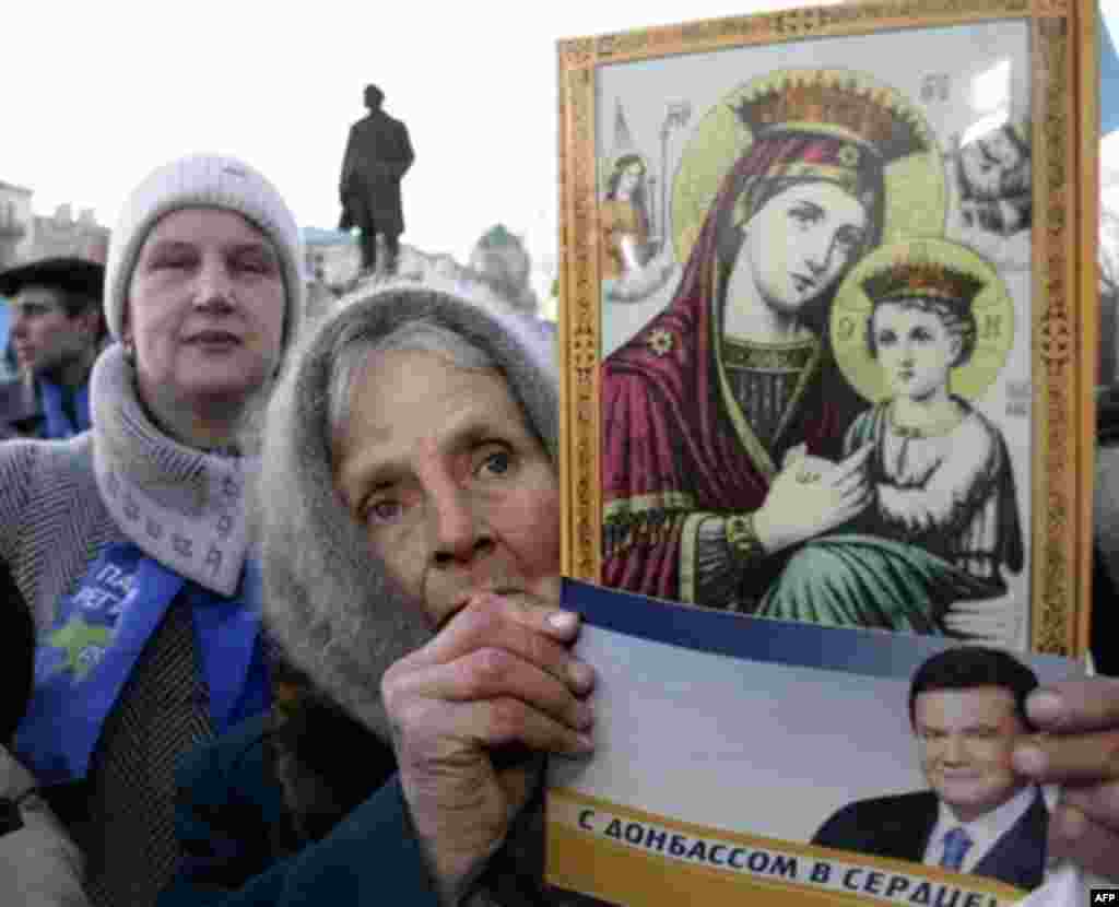An elderly woman in the heart of the Donbas, Donestsk, holds a flyer for Viktor Yanukovych that reads "With the Donbass in my heart!" (AFP) - In elections in March, the party of Ukrainian President Viktor Yushchenko was trounced. But with the Yuliya Tymoshenko Bloc topping the vote, an Orange government seemed possible. But a last-ditch deal collapsed, bringing to power Viktor Yanukovych, the man whose rigged presidential victory prompted the Orange Revolution.