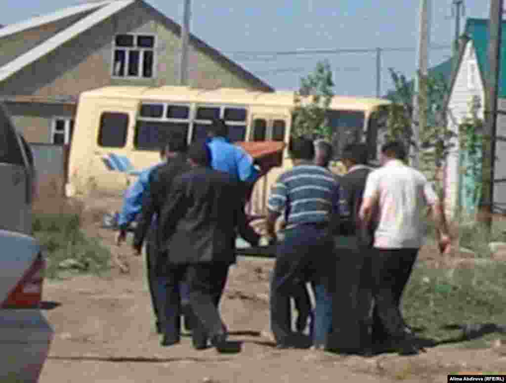 Family and acquaintances carry alleged suicide bomber Rahimjan Makhatov's remains, wrapped in a carpet, to prepare them for burial in his hometown of Aqtobe. 