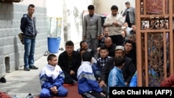 Muslim Uyghur children join the adults at a mosque for Friday Prayers in Urumqi in China's Xinjiang region.