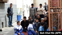 Burrat dhe të rinjët ujgurë në një xhami në rajonin Xinjiang