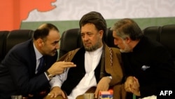 FILE: Abdullah Abdullah (R) and Atta Mohammad Noor (L) speak with Abdullah's deputy Mohammad Mohaqiq (C) during a political gathering in Kabul in 2013.