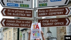 Активіст тримає агітаційний плакат біля дорожнього вказівника на користь одностатевих шлюбів, місто Донегол, Ірландія, 21 травня 2015 року