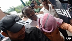 Үнді полицейлері айып тағылған жасөспірімді (басын бүркеп алған) сот залына әкеле жатыр. Нью-Дели, 25 шілде 2013 жыл.