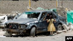 زن و کودک یمنی در منطقه‌ای از صنعا، پایتخت، که هدف حملات هوایی ائتلاف قرار گرفته است