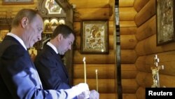 Володимир Путін і Дмитро Медведєв ставлять свічки в пам’ять жертв польської авіакатастрофи