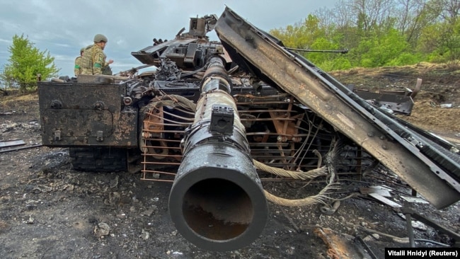 Ushtarët ukrainas qëndrojnë pranë një tanku rus T-90M të shkatërruar nga Forcat e Armatosura të Ukrainës pranë fshatit Stary Saltov në rajonin e Kharkiv, 9 maj 2022.
