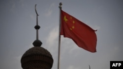 На снятом 4 июня 2019 года фото — государственный флаг Китая над мечетью в городе Кашгаре в Синьцзян-Уйгурском автономном районе (СУАР) Китая. 