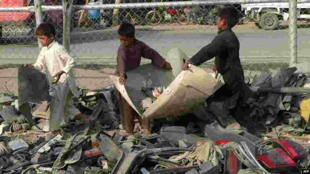 Children collect scrap metal, to be sold in Pakistan, at the Afghan-Pakistani border town of Torkham in Nangarhar Province on July 10. (AFP/Noorullah Shirzada)