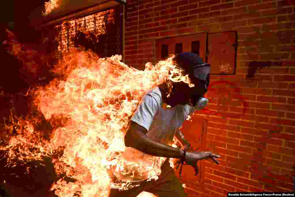 The World Press Photo of the Year shows 28-year-old Jose Victor Salazar Balza catching fire amid violent clashes with riot police during a protest against President Nicolas Maduro, in Caracas, Venezuela. 