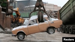 Kran Sovet dövründən qalma "Moskviç" avtomobilini emal edir.