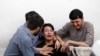 Afghan men mourn after a blast in a hospital in Kabul on August 15.